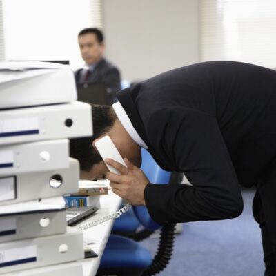 電話をかけながら頭を下げている男性