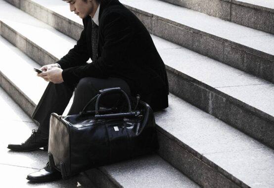 街中の会談で座ってしんみりしているスーツの男性
