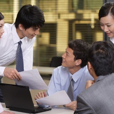 明るい顔で話し合う職場の人たち
