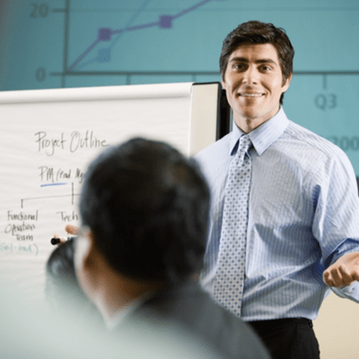 ホワイトボードの前で説明するビジネスマン